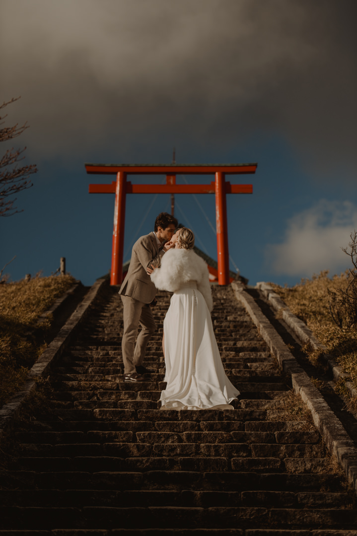 Hakone Elopement - couple is kissing in front of the mountain shrine 