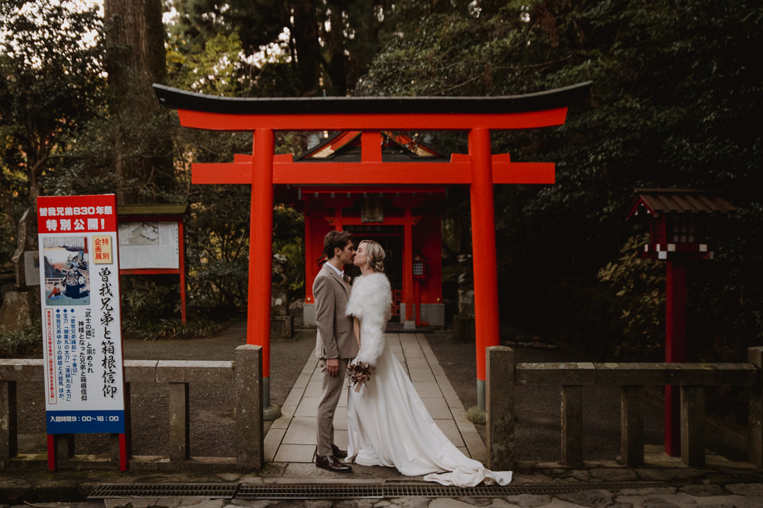 Hakone Elopement - couple is kissing at the middle of red torii 