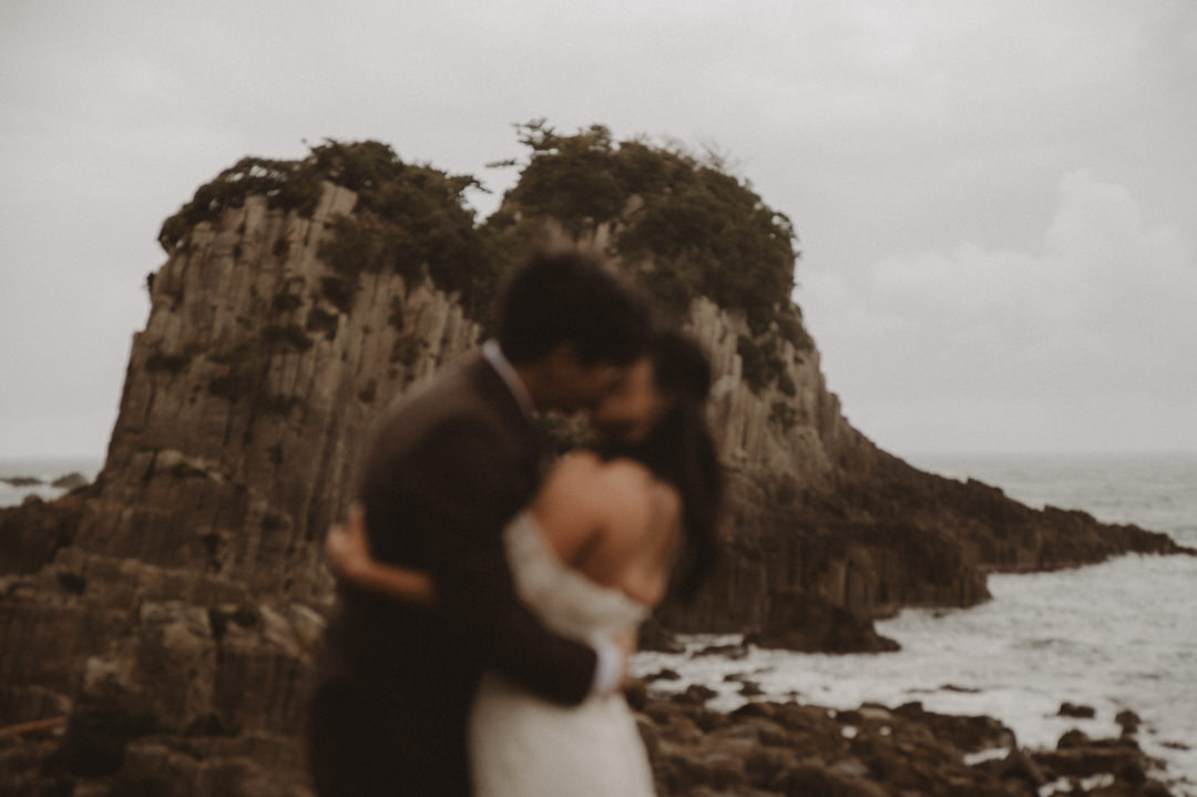 Japan Roadtrip Elopement - Couple kissing in front of the rock formation 
