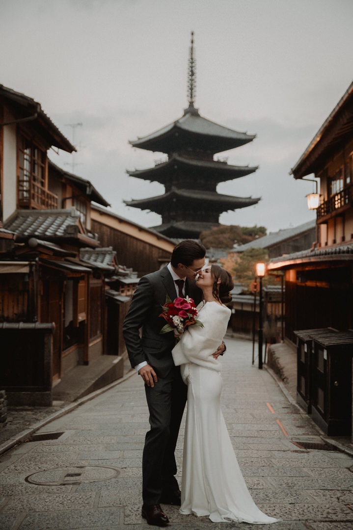 Private Elopement Kyoto - Couple looking at each other in front of pagoda