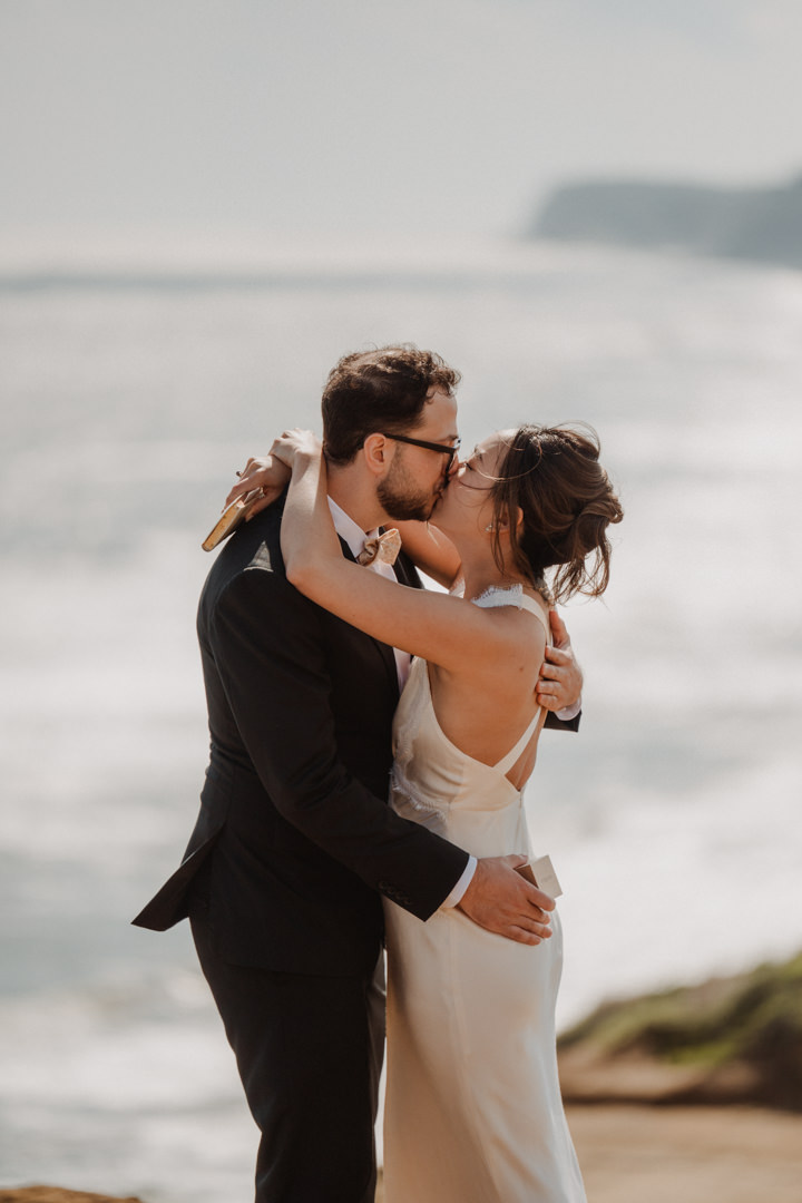 The couple kisses on the cliff. Ocean Cliff Elopement in Japan.